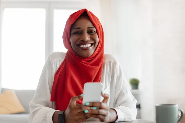 Retrato Sonriente Dama Negra Hijab Sentada Casa Con Teléfono Celular —  Fotos de Stock