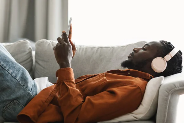 Entspannter Schwarzer Typ Mit Kopfhörern Der Musik Auf Dem Smartphone — Stockfoto