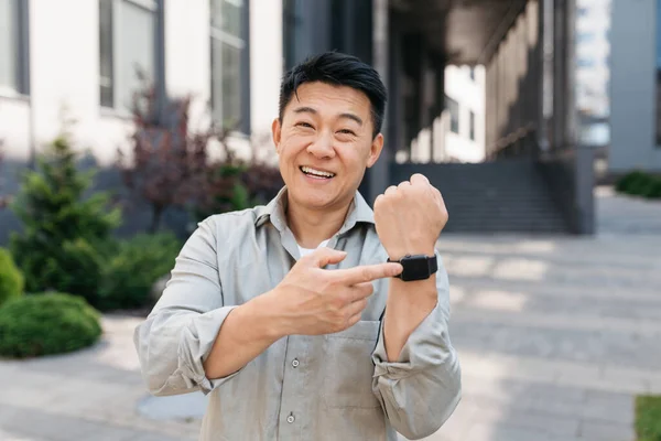 Modern Bilek Saatini Işaret Eden Mutlu Asyalı Işadamının Portresi Kameraya — Stok fotoğraf