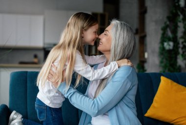 Tatmin olmuş küçük kız ve Avrupalı yaşlı kadın burunlarına dokunur, birlikte eğlenir, oturma odasının iç kısımlarında hassas anın tadını çıkarırlar. Aşk ve aile ilişkisi, oyun, insanlar evde duygular ve yaşam tarzı