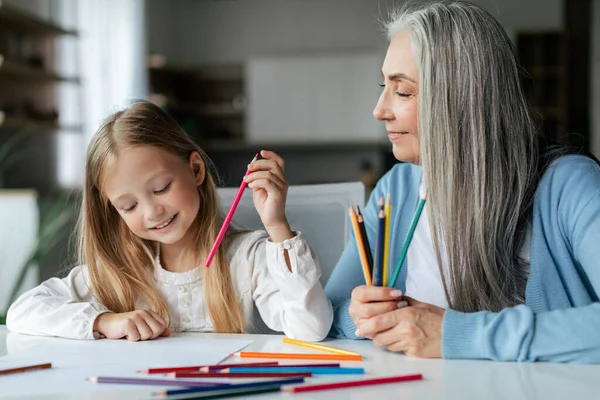 Szczęśliwa Biała Dziewczynka Starszą Babcią Kolorowymi Ołówkami Narysować Obraz Stole — Zdjęcie stockowe