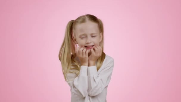子供達のストレス 彼女のあごに指で触れ何かを恐れているピンクのスタジオの背景スローモーション — ストック動画