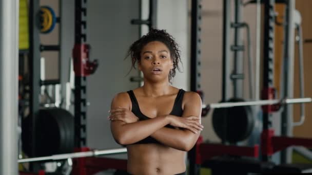 体育动机概念 有自信 汗流浃背的非洲裔美国女运动员交叉胳膊的画像 在体育馆进行密集训练后看着镜头 动作缓慢 — 图库视频影像