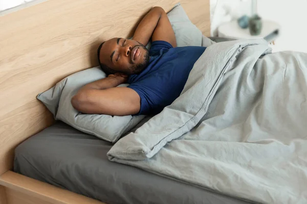 Afrika Kökenli Amerikalı Erkek Evinde Modern Yatak Odasında Battaniyeyle Örtülü — Stok fotoğraf