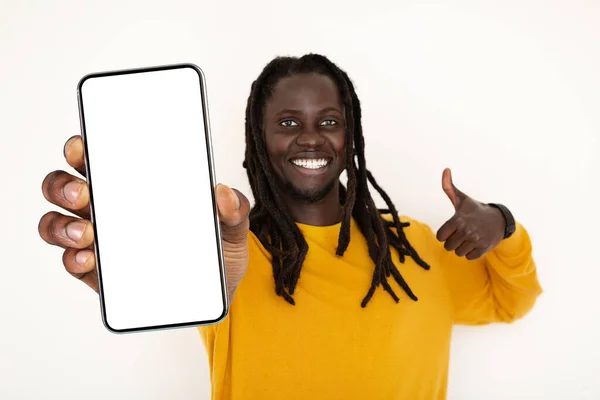 Joven Negro Positivo Sosteniendo Smartphone Blanco Mostrando Gesto Pulgar Hacia — Foto de Stock