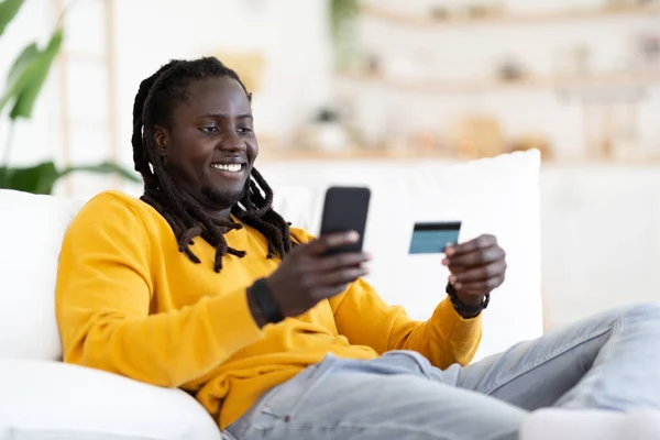 Sonriente Joven Negro Hombre Haciendo Compras Línea Con Teléfono Inteligente —  Fotos de Stock