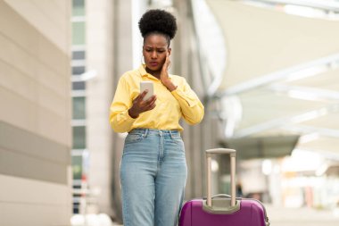 Kötü Mesaj Okumak ve Gezici Başvuru Havalimanı 'nda Bavulla Bekleme' de Uçuş Rezervasyonunda Sorun Yaşayan Siyah Kadın Turist. Turizm Sorunları Konsepti