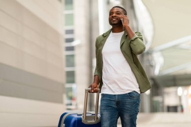 Afrikalı Amerikalı Gezgin, havaalanında bavulla telefonda konuşuyor. Seyahate çıkan erkek turist gezgin servisini arıyor. Her Zaman İrtibat, Mobil İletişim Kavramı