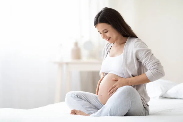 Lachende Jonge Zwangere Vrouw Zit Bed Witte Slaapkamer Thuis Knuffelen — Stockfoto