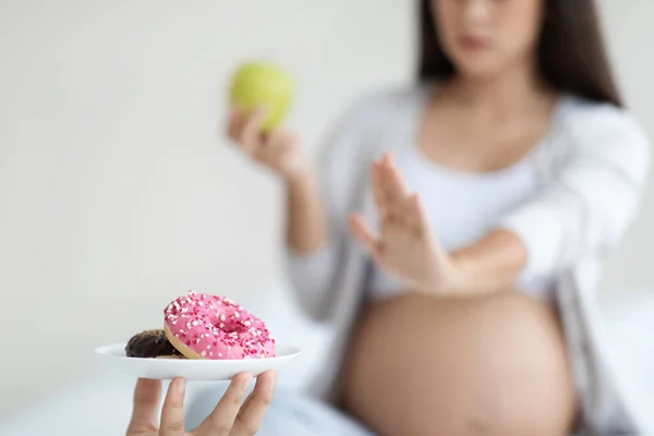 Unrecognizable Pregnant Woman Holding Green Apple Rejecting Plate Donuts Cropped — Stock Photo, Image