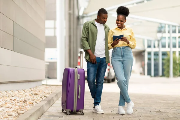 Turizm. Afro-Amerikan Turistler Pasaportlu Çiftler, Bavullarıyla Açık Hava Alanı 'nın yanında duruyorlar. Milenyum Eşleri Birlikte Seyahat Ediyor. Tatil Seyahat Konsepti. Tam Uzunluk Çekimi