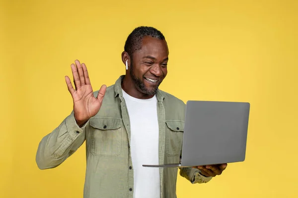 Vrolijke Volwassen Zwarte Man Draadloze Hoofdtelefoon Zwaaiende Hand Kijk Naar — Stockfoto