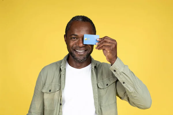 평범하고 남자가 카드를 온라인 쇼핑을 즐기고 노란색 배경에 고립된 스튜디오에서 — 스톡 사진