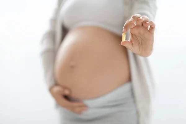 无法辨认的孕妇在白色背景下显示明胶胶囊丸 服用补充剂 复制空间 怀孕期间的保健概念 — 图库照片