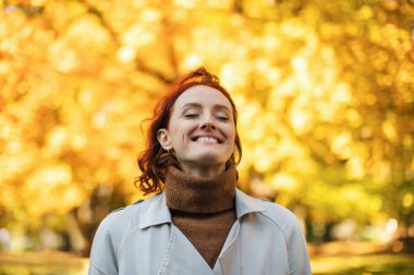 Kafkasya 'nın bin yıllık kızıl saçlı, yağmurluklu dişisi sıcak bir sonbahar ve özgürlüğün tadını çıkarıyor. Parkta sarı yapraklarla temiz hava soluyor. Covid-19 karantinasının sonunda şehirde tek başına dinlen ve dinlen.