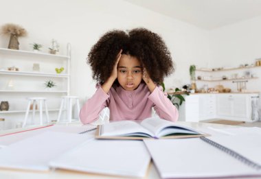 Kitaplarla, not defterleriyle dolu masasında oturan, ödevlerini yalnız yapan, kafasına dokunan, stresli bir çocuk olan Afro-Amerikan okul kızı. Eğitimde zorluklar