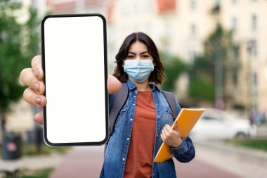 Tıp Maskeli Genç Arap Kadın Şehir Caddesinde Açık havada dururken Boş Akıllı Telefonu Gösteriyor, Orta Doğu Kadın Öğrencisi Yeni Mobil Uygulama veya Web Sitesi Tavsiye Ediyor, Colage, Model