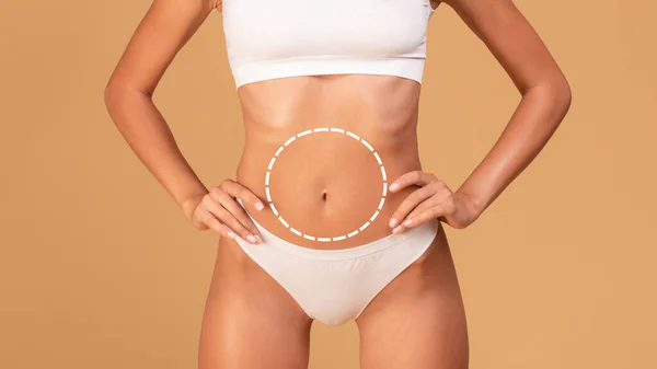 Body shaping concept. Female body with drawing round line on belly, unrecognizable woman with fit figure in white underwear standing over beige studio background, collage