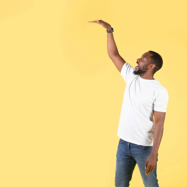 Feliz Hombre Afroamericano Levantando Brazo Midiendo Mostrando Altura Objetos Invisibles — Foto de Stock
