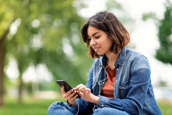 Gülümseyen Arap Kız Öğrenci Müzik Dinlerken Internette Akıllı Telefonuyla Dolaşırken — Stok fotoğraf