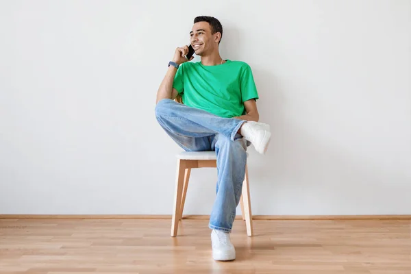 Evdeki Işık Duvarına Yaslanmış Bir Sandalyede Otururken Cep Telefonuyla Konuşan — Stok fotoğraf