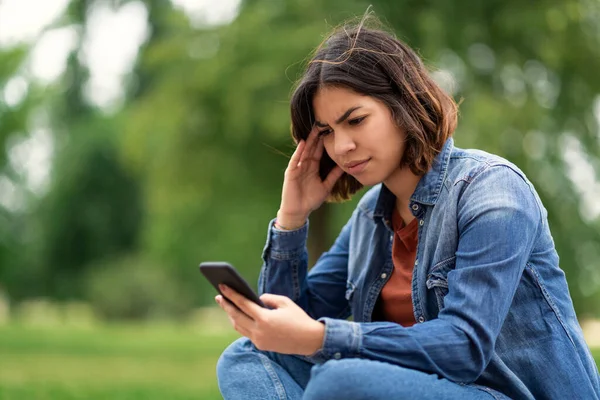 Preocupado Joven Árabe Femenino Mensaje Lectura Teléfono Inteligente Mientras Sienta —  Fotos de Stock