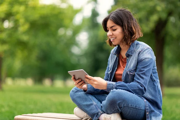 Güzel Arap Genç Bayan Öğrenci Dışarıda Otururken Dijital Tablet Kullanıyor — Stok fotoğraf