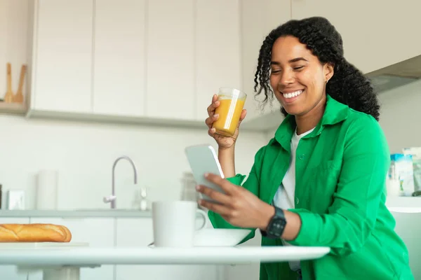 Happy Black Female Using Phone Texting Drinking Orange Juice Having — 스톡 사진