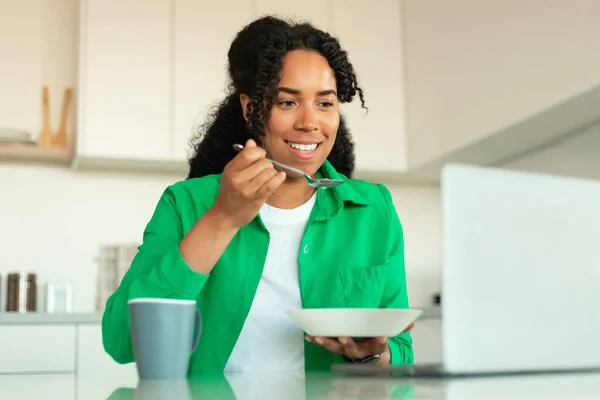 Glad Svart Kvinnlig Frilansare Använder Laptop Äta Äta Frukost Sitter — Stockfoto