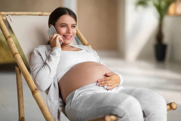 Lachende Jonge Zwangere Vrouw Praten Mobiele Telefoon Ontspannen Stoel Thuis — Stockfoto