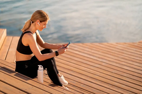 Mulher Desportiva Meia Idade Usando Smartphone Enquanto Relaxa Após Treinamento — Fotografia de Stock