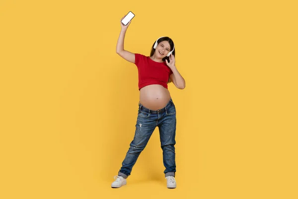 Ευτυχισμένη Νεαρή Έγκυος Γυναίκα Ακουστικά Που Ακούει Μουσική Στο Smartphone — Φωτογραφία Αρχείου
