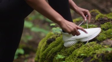 Güvenli spor eğitimi. Tanınmayan siyah bir sporcu spor ayakkabılarını bağlıyor, spor yaparken ayakkabılarını tamir ediyor, yakın çekim, yavaş çekim, takip çekimi...