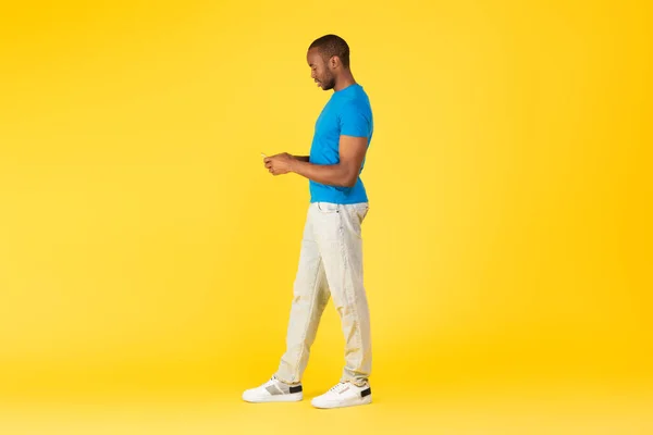 Stüdyoda Sarı Arkaplan Üzerindeyken Zekice Mesaj Kullanan Siyah Erkek Uzunluğu — Stok fotoğraf