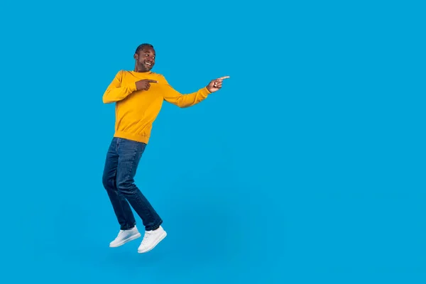 길이의 파노라마 스튜디오 광고를 공간에 가볍게 점프하고 지적에 흥분한 아프리카 — 스톡 사진