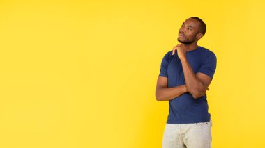 Düşünen dalgın siyahi adam, sarı stüdyonun arkasında duran mesaj için boş alana bakan çene pozisyonuna dokunmayı düşünüyor. Bir düşüneyim. Panorama