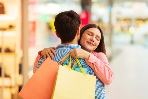 Esposo Abrazando Esposa Comprando Juntos Posando Sosteniendo Bolsas Compras Pie —  Fotos de Stock