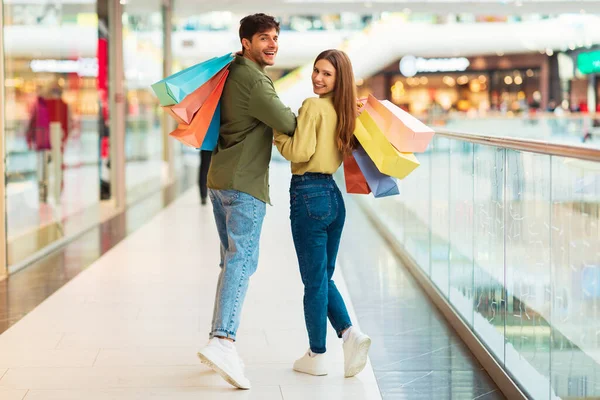 Joyful Buyers Couple Shopping Together Walking Looking Back Camera Posing — Stock Photo, Image