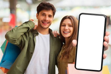 Alışveriş Uygulaması. Neşeli Alıcılar Modern AVM 'de Duran Mobil Bankacılık Uygulamasına Büyük Boş Ekranlı Akıllı Telefon Gösteriyor. Seçici Odaklanma