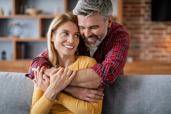 快乐的欧洲中年男人拥抱着女人 享受舒适 在舒适的客厅里的沙发上浪漫 — 图库照片