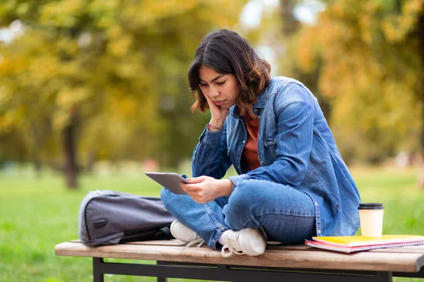 Açık Hava Tezgahında Otururken Dijital Tablet Kullanan Yorgun Arap Öğrenci — Stok fotoğraf