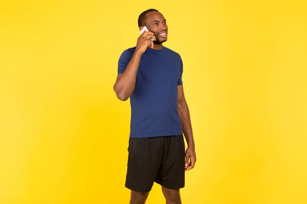Neşeli Siyah Sporcu Cep Telefonuyla Konuşuyor Yan Bakış Sarı Arka — Stok fotoğraf