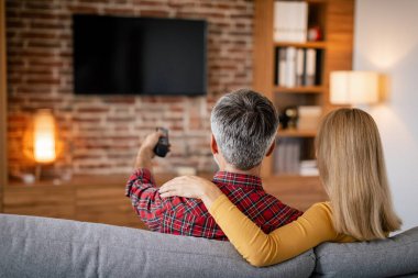 Uzaktan kumandalı sakin Avrupalı bir aile, oturma odasının iç kısmında boş ekranı olan boş zamanların tadını çıkarıyor. Birlikte eğlence ve film akşamı, son dakika haberleri.