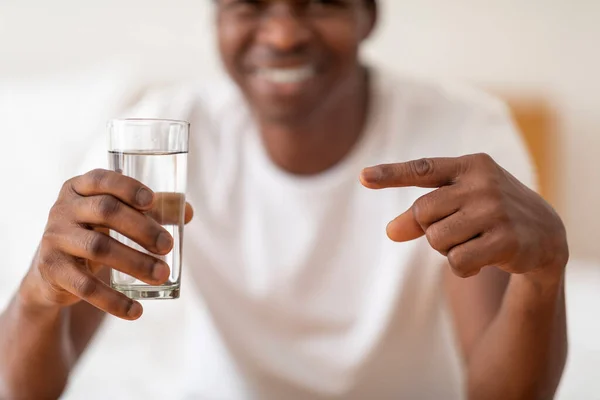 Smiling Black Guy Holding Glass Water Pointing Closeup Shot Young — Stok Foto