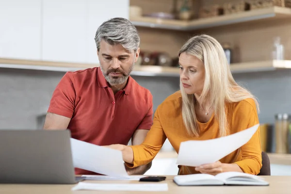 中年男人和妻子坐在电脑前的桌子前 检查信件 为他们的债务烦恼 厨房的内部 复制的空间 2022年危机期间的金融遗留问题 — 图库照片