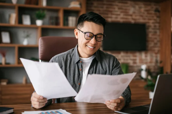 Усміхнений Дорослий Корейський Чоловік Окулярах Працює Паперами Графіками Графіками Столом — стокове фото
