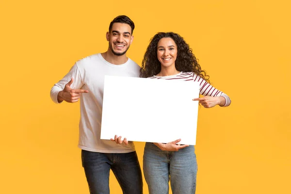 Plaats Voor Happy Arab Couple Holding Pointing Blank White Placard — Stockfoto