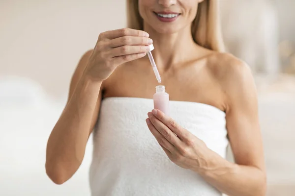 Mature Woman Applying Facial Serum Doing Skincare Routine Moisturizing Skin — Stock Photo, Image