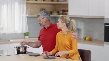 Dünya çapında yoksulluk sorunu. Zavallı orta yaşlı karı koca mutfakta boş tabaklar ile oturuyorlar, adam otları yiyeceksiz kontrol ediyor, yavaş çekim, boş alan