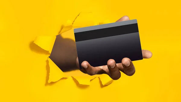 Чорна Чоловіча Рука Тримає Банківську Кредитну Картку Рваному Отворі Жовтого — стокове фото